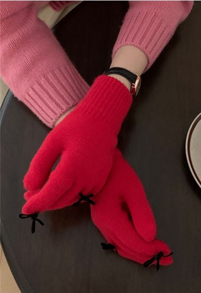 Gants en tricot avec trou pour les doigts et décoration avec nœud papillon en rouge