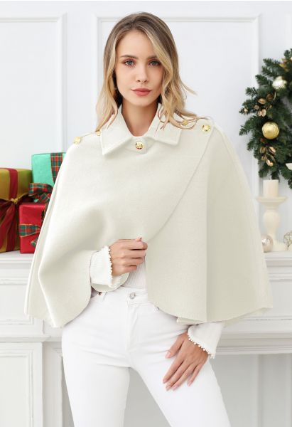 Cape en tricot enveloppée de boutons dorés en crème