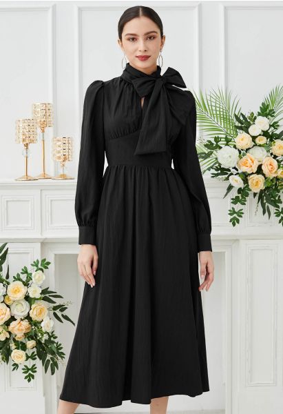 Superbe robe mi-longue à découpes et nœud papillon en noir