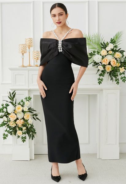 Robe longue noire à épaules dénudées et gros nœud avec décor en strass