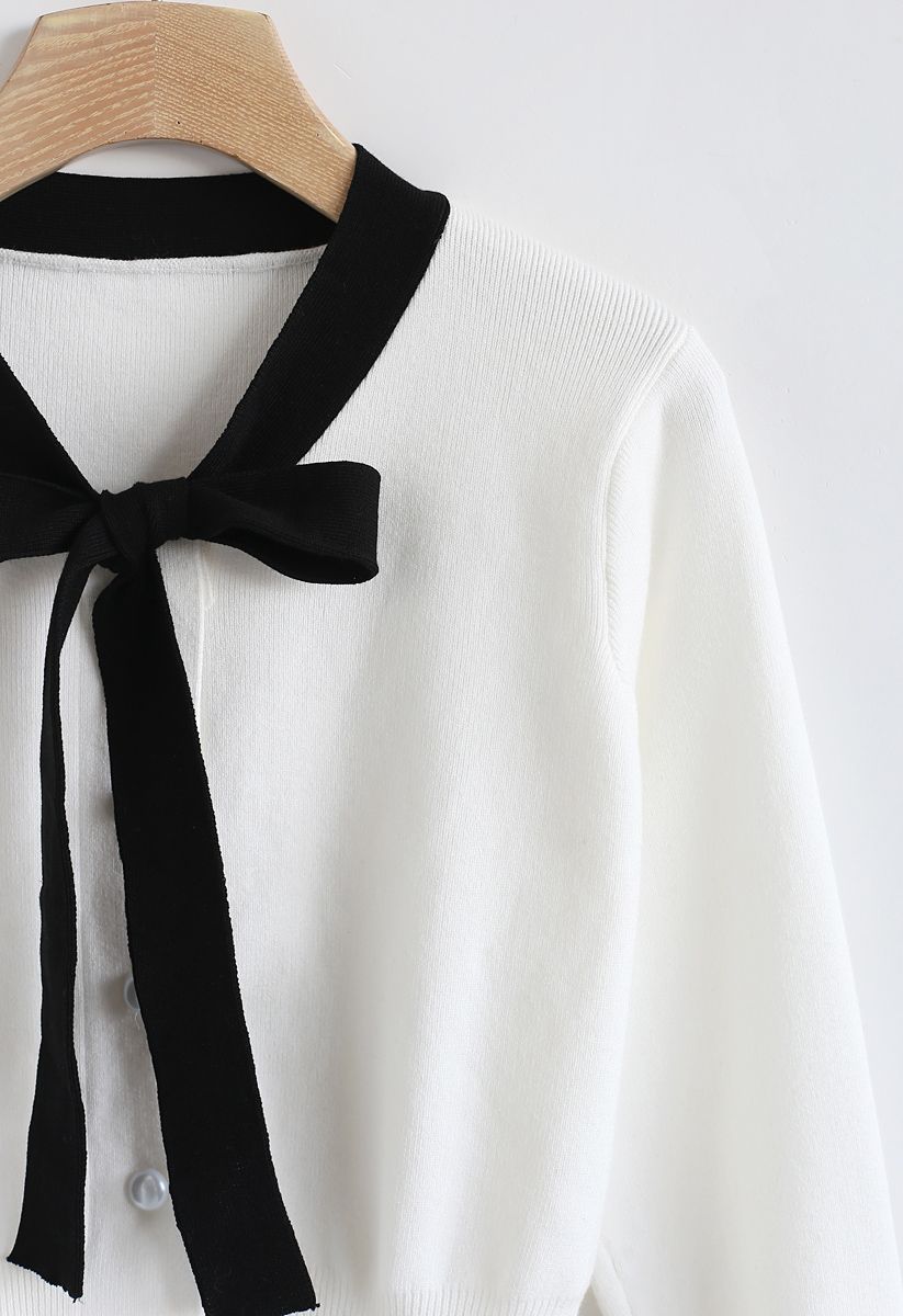 Pull en tricot boutonné avec nœud papillon en blanc