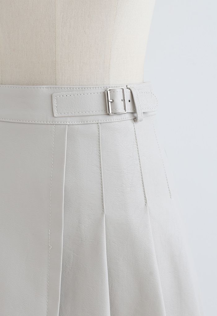 Mini-jupe plissée en faux cuir avec ceinture en crème