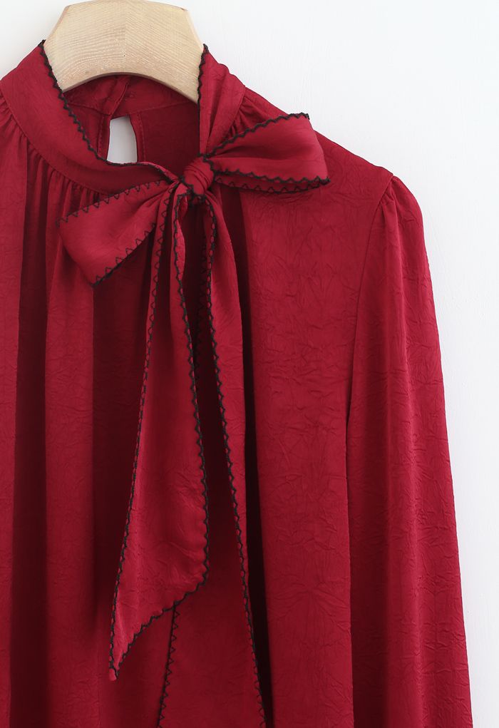 Top en satin texturé avec nœud à bords cousus en rouge