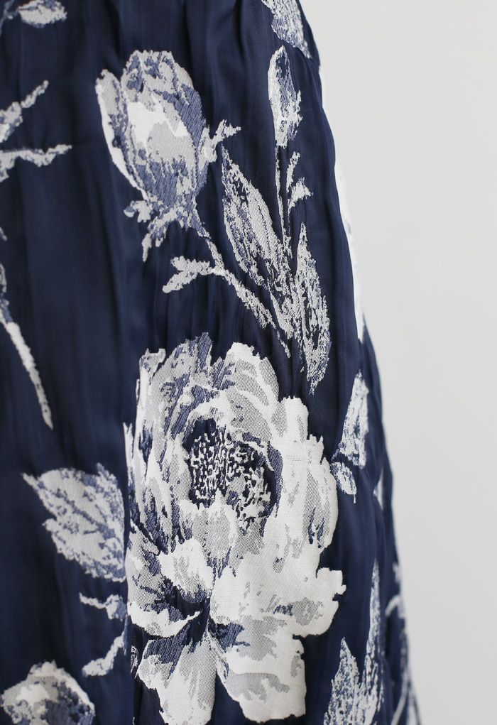 Jupe mi-longue plissée en jacquard fleuri bleu marine