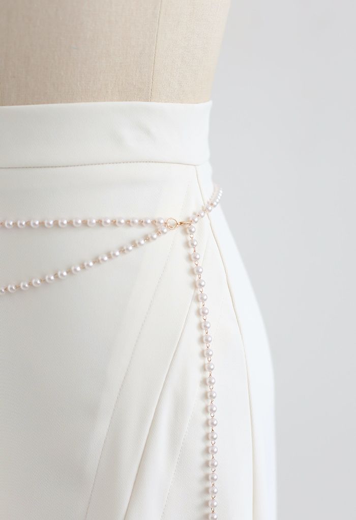 Jupe mi-longue fendue sur le devant avec chaîne de perles en crème
