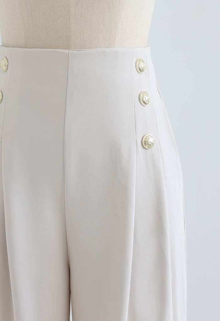 Pantalon plissé orné de boutons en ivoire
