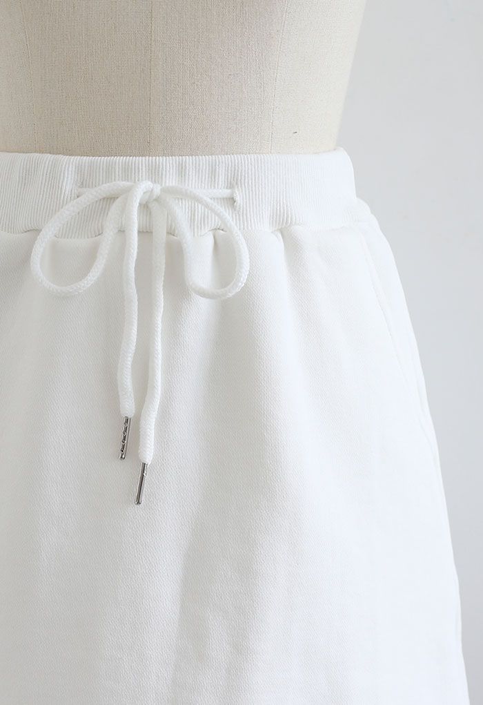 Mini jupe-short en coton avec poche à cordon en blanc