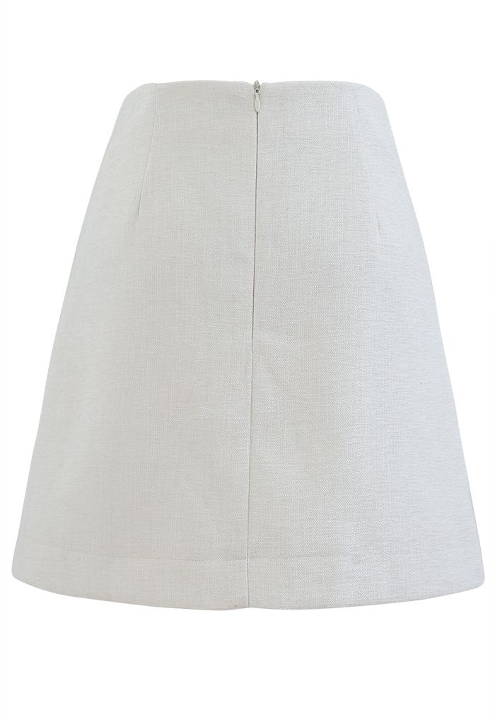 Mini-jupe en tweed scintillant avec poche plaquée en ivoire
