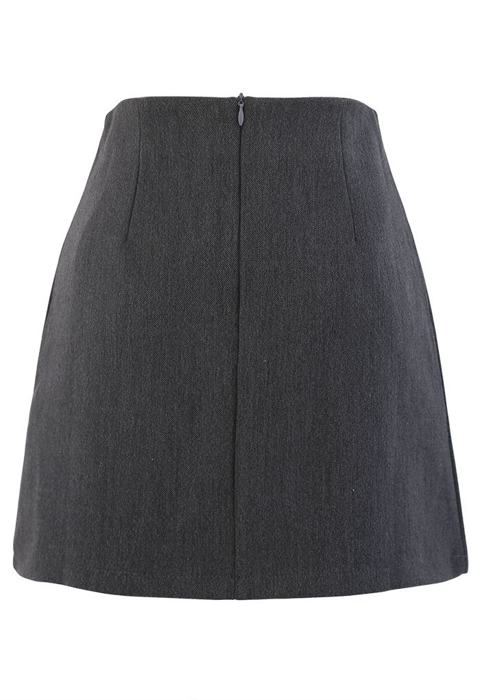 Mini-jupe plissée à rabat boutonné en gris