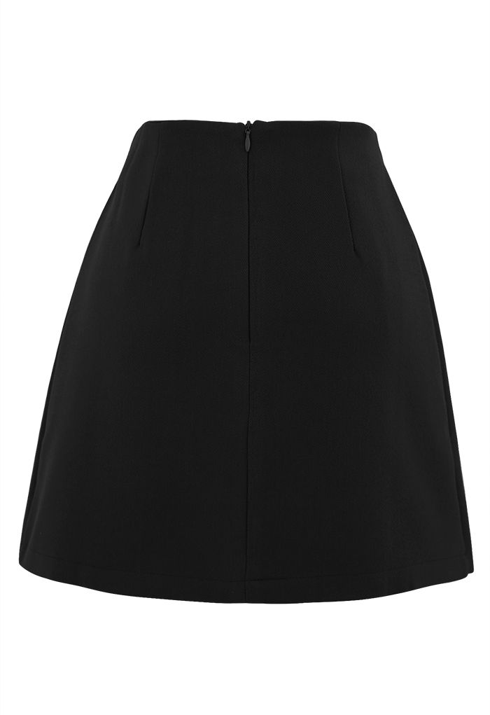 Mini-jupe plissée à rabat boutonné en noir