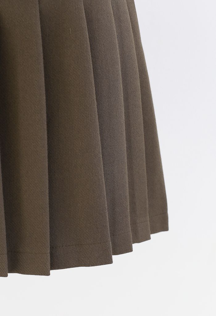Mini-jupe plissée à rabat boutonné en olive