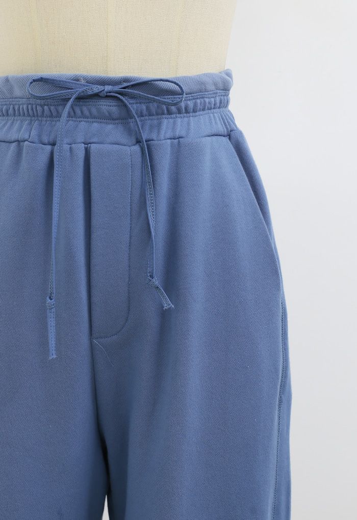 Jogging avec poches à cordon de serrage et ourlet à revers en bleu