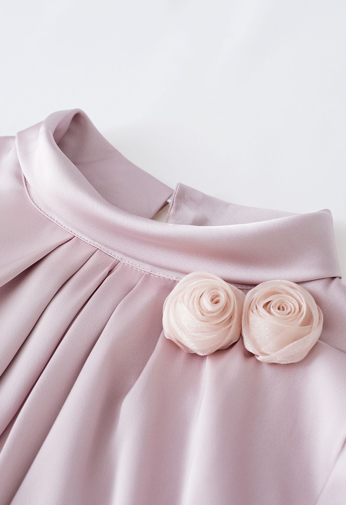 Chemise en satin à col montant avec broche rose en rose