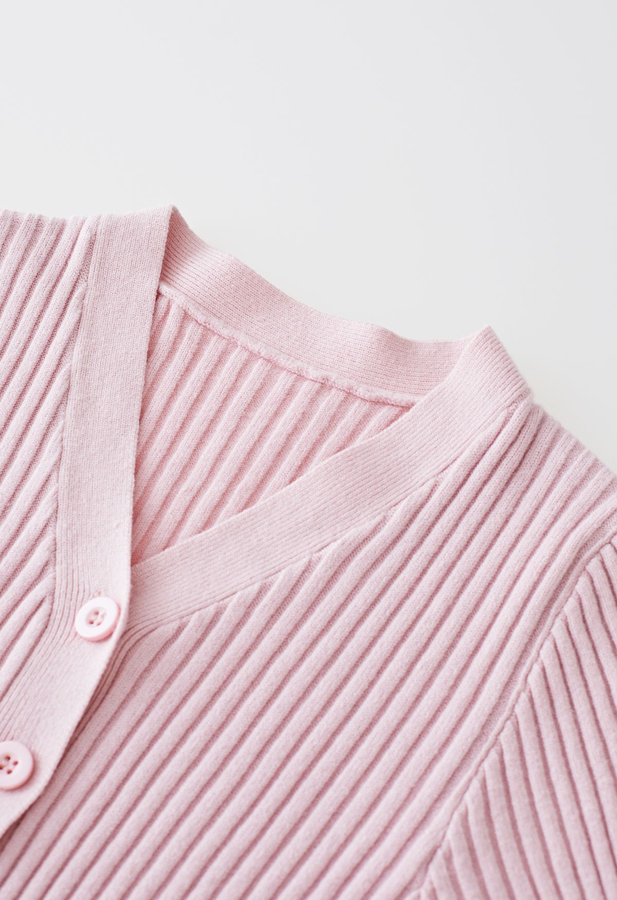 Robe en tricot boutonnée à la taille avec nœud papillon et encolure en V en rose