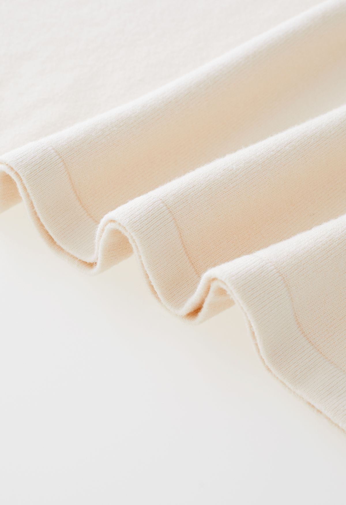 Robe en tricot boutonnée à la taille avec nœud papillon et encolure en V en crème