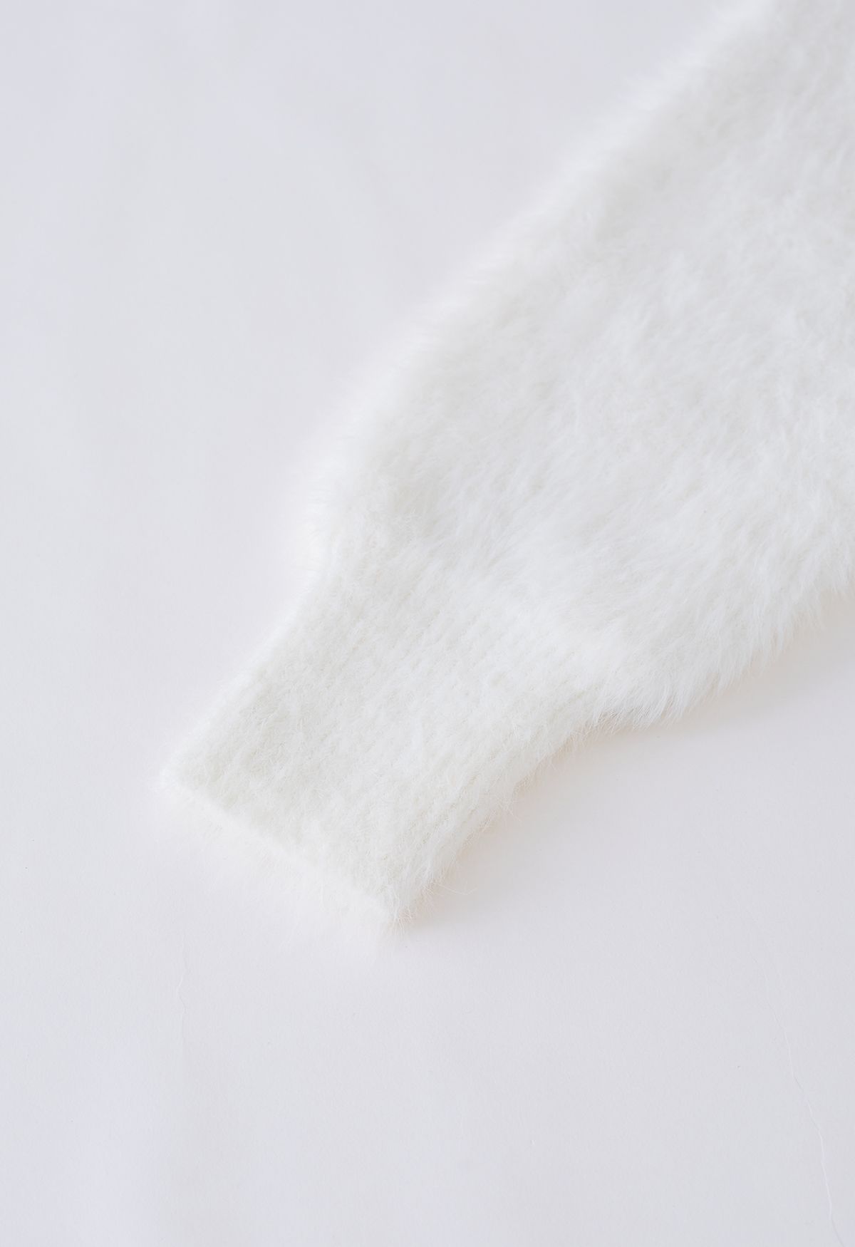 Cardigan en tricot pelucheux avec broche à nœud diamant en blanc