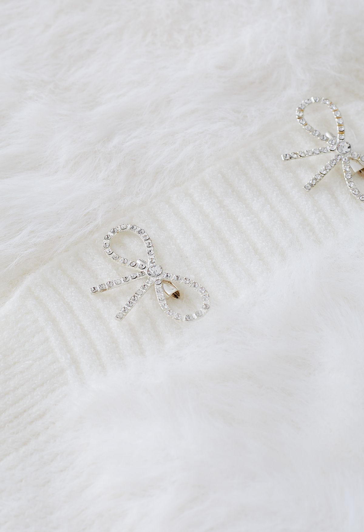 Cardigan en tricot pelucheux avec broche à nœud diamant en blanc