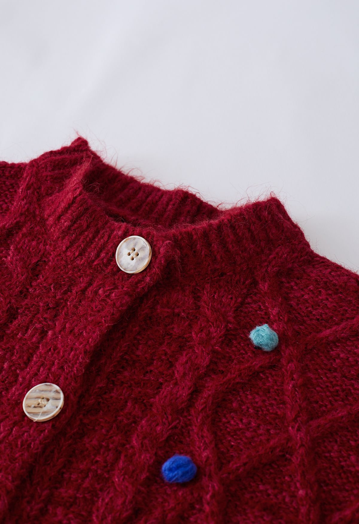 Cardigan coloré en tricot à losanges et pompons en rouge
