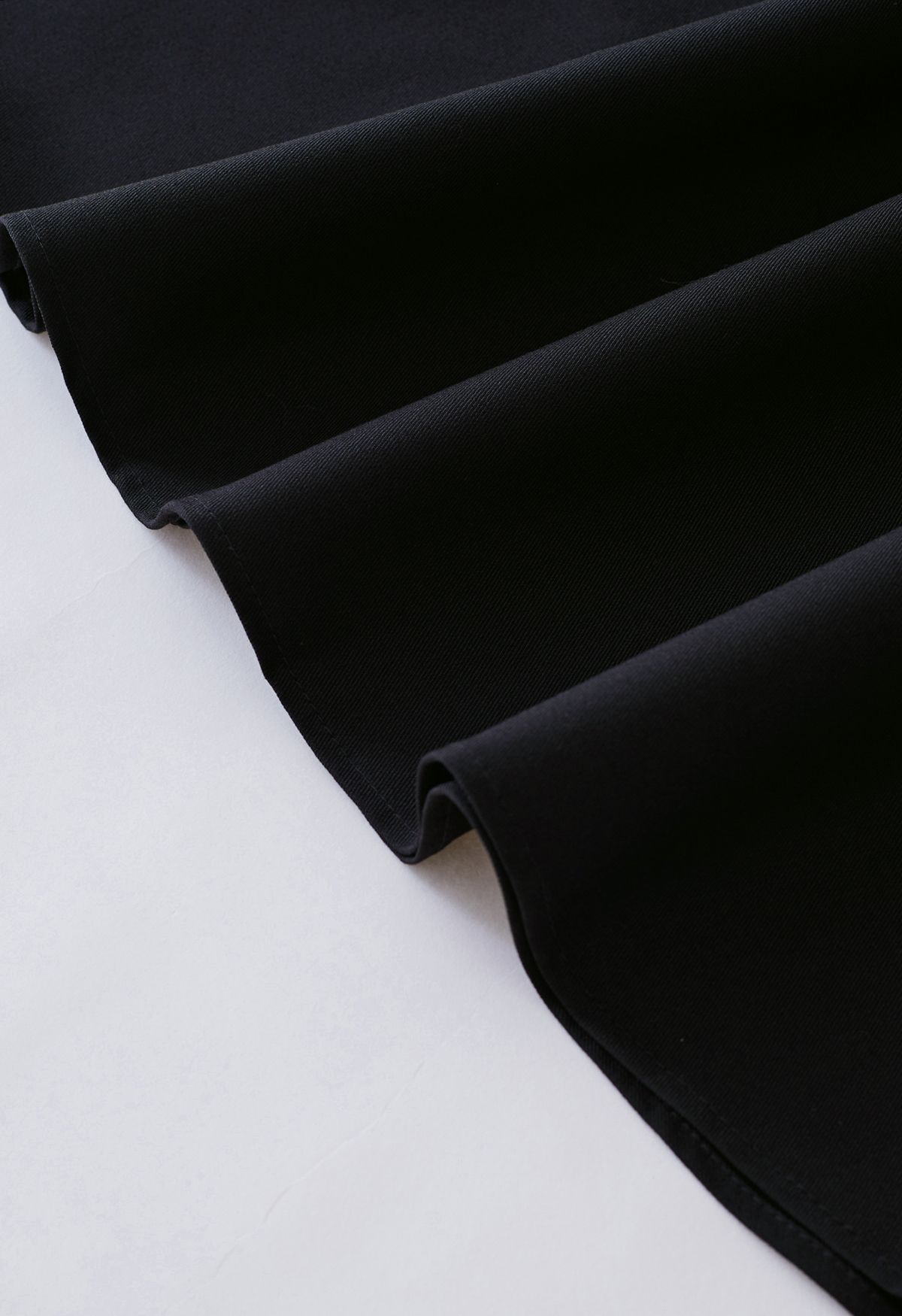 Jupe mi-longue à ceinture plissée et poches latérales en noir