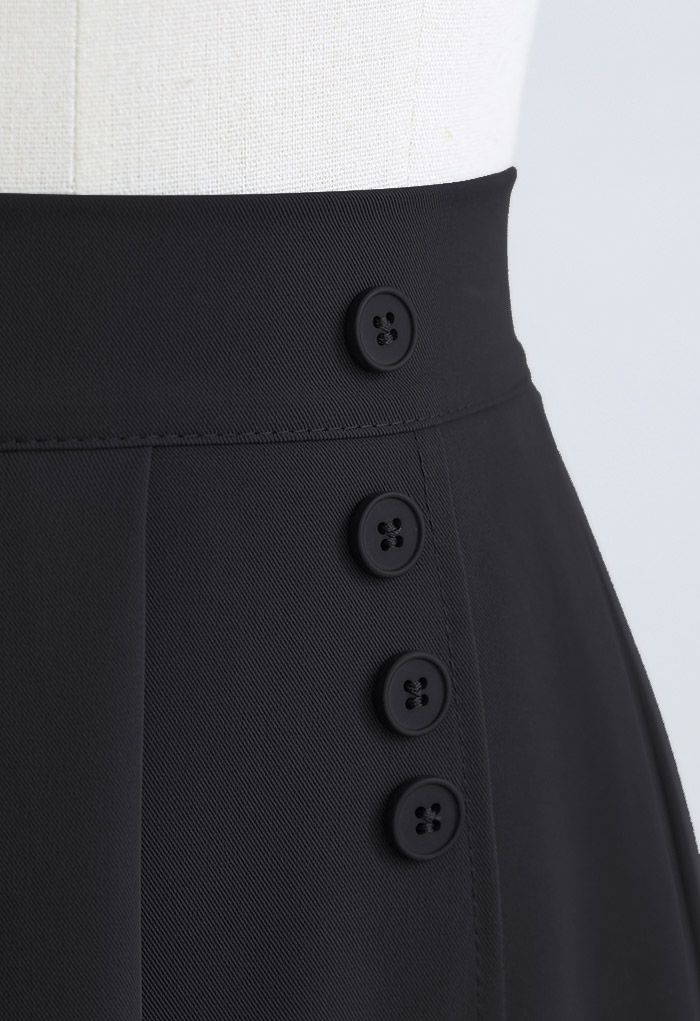 Jupe plissée décorée de quatre boutons en noir