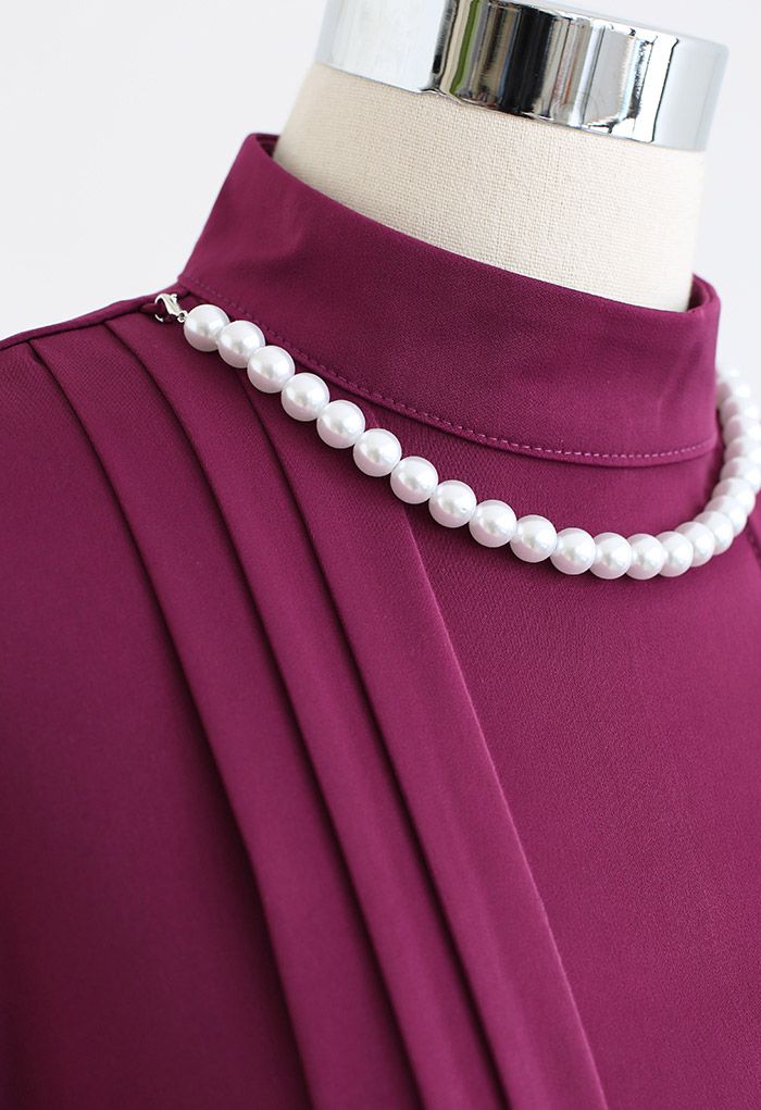 Chemise à plis creux et collier de perles