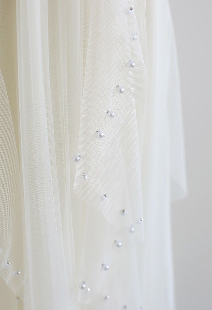 Jupe plissée en tulle à décor de perles dispersées en crème