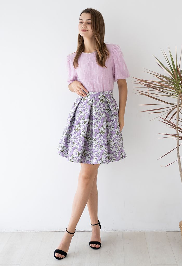 Superbe mini-jupe plissée en jacquard de fleurs en violet