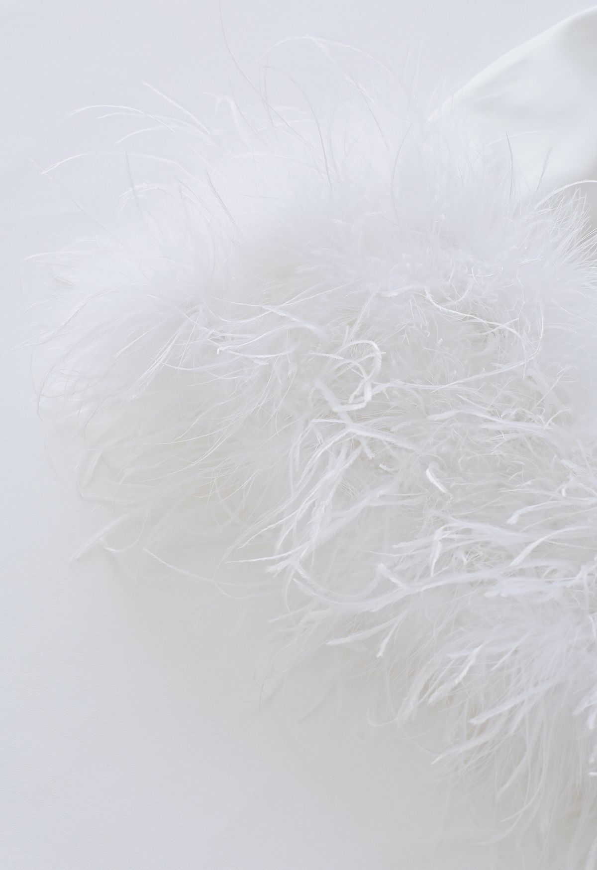 Robe en satin à manches longues et plumes éthérées en blanc