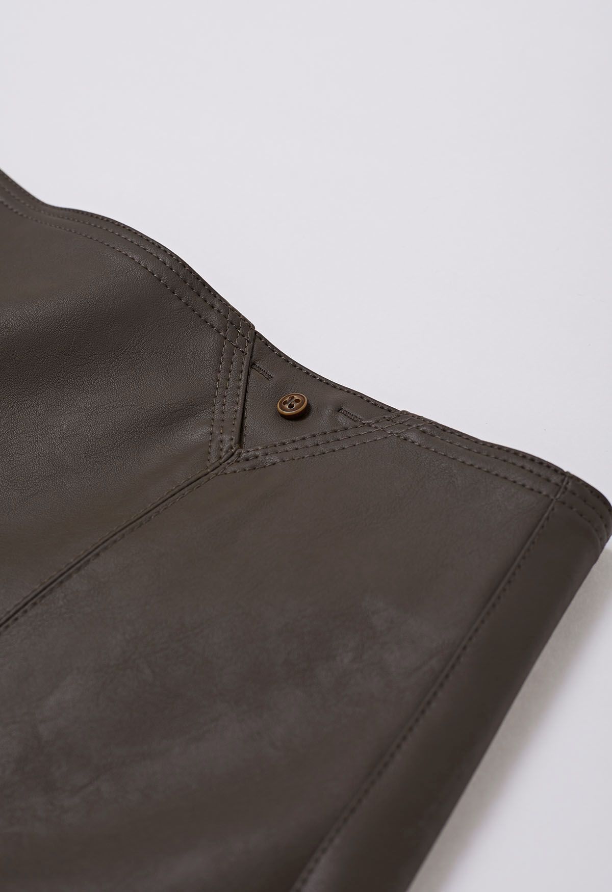 Mini-jupe en similicuir bordée de boutons en marron
