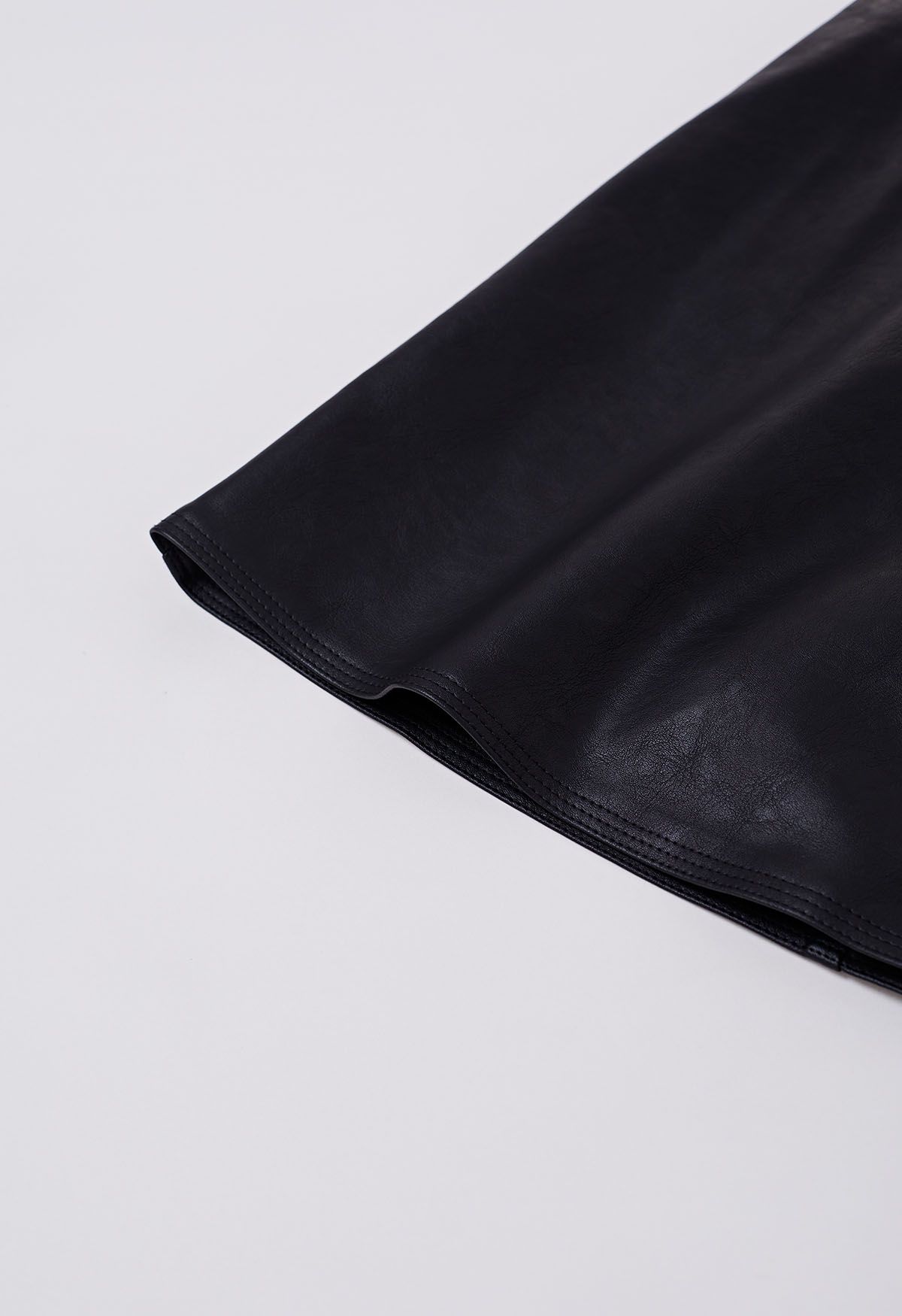 Mini-jupe en similicuir bordée de boutons en noir