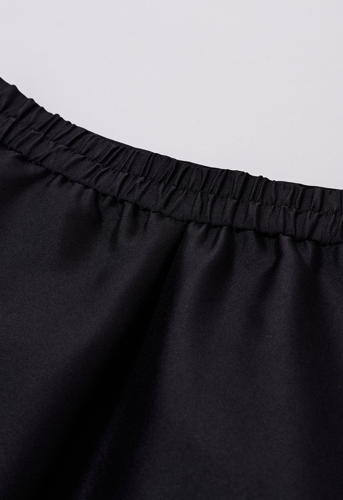 Jupe mi-longue trapèze plissée élégante avec poches latérales en noir