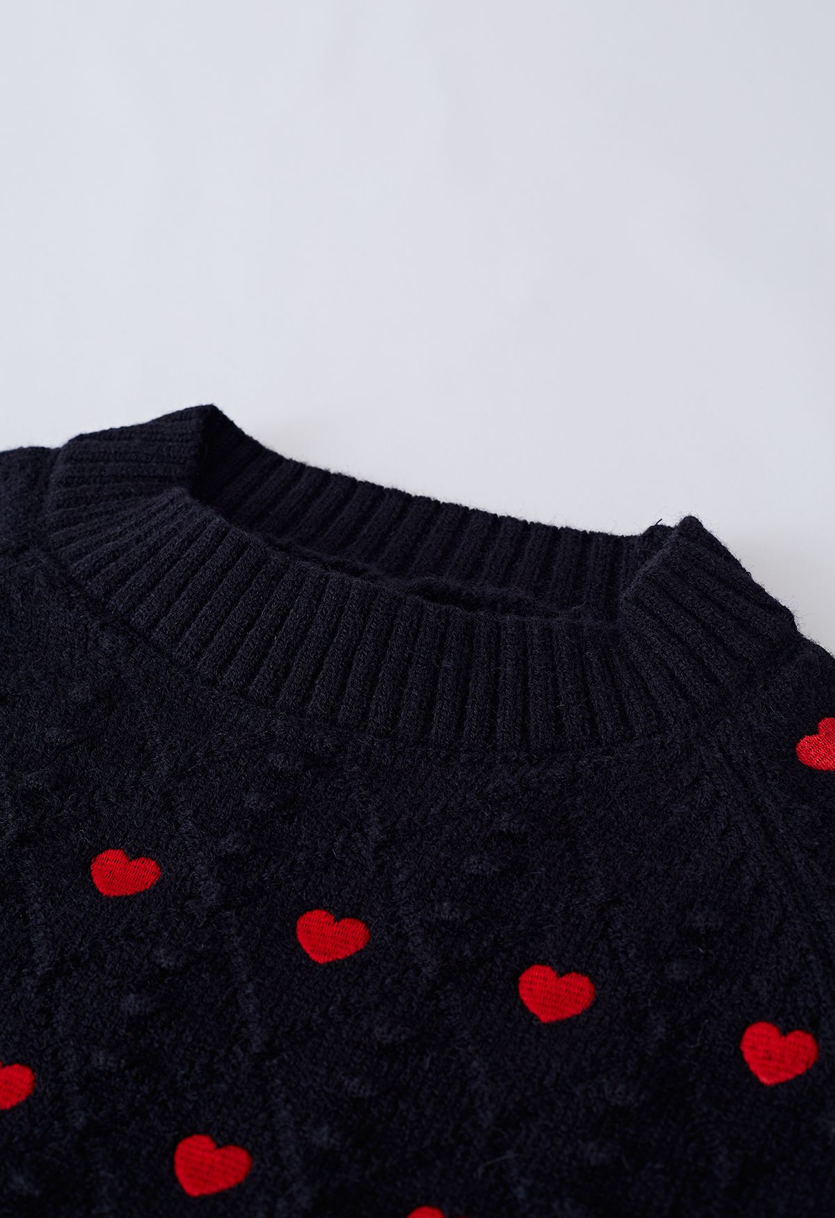 Pull court en tricot brodé en relief plein de cœurs en noir