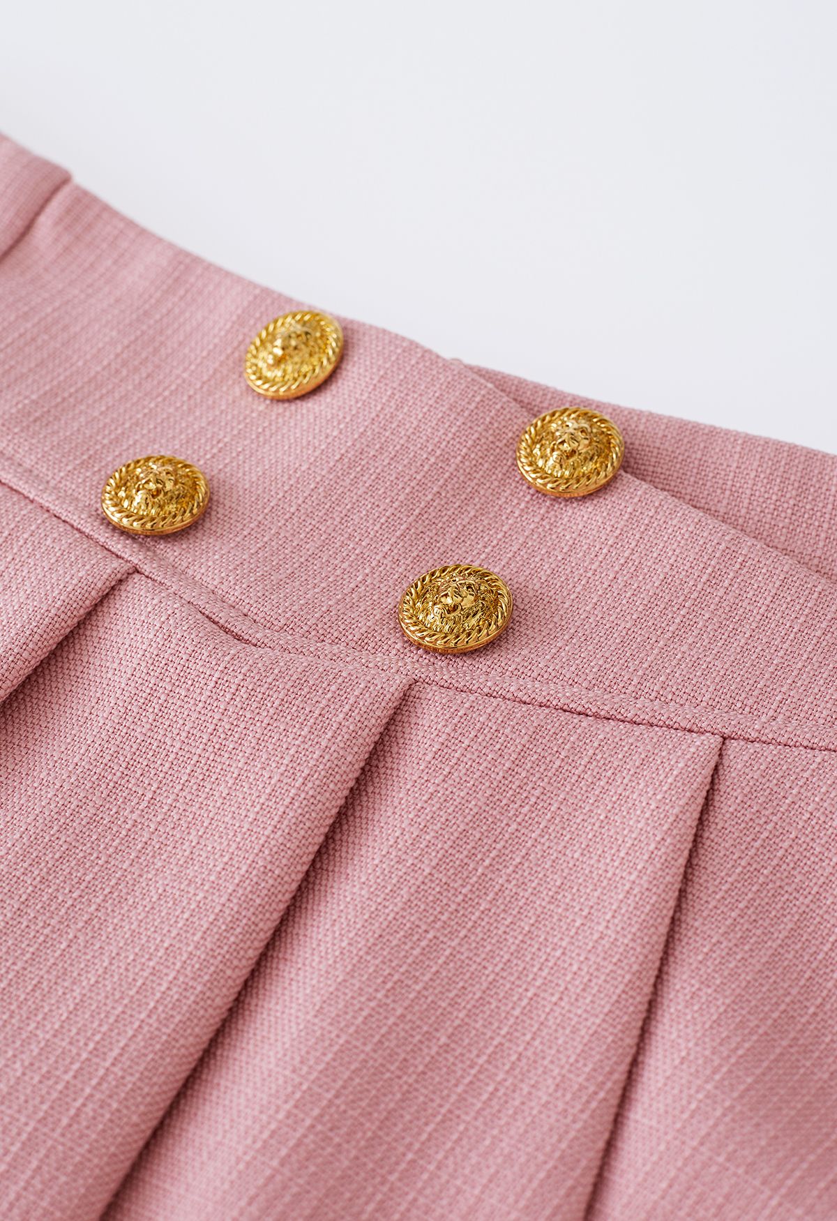 Mini-jupe évasée plissée à boutons dorés en rose