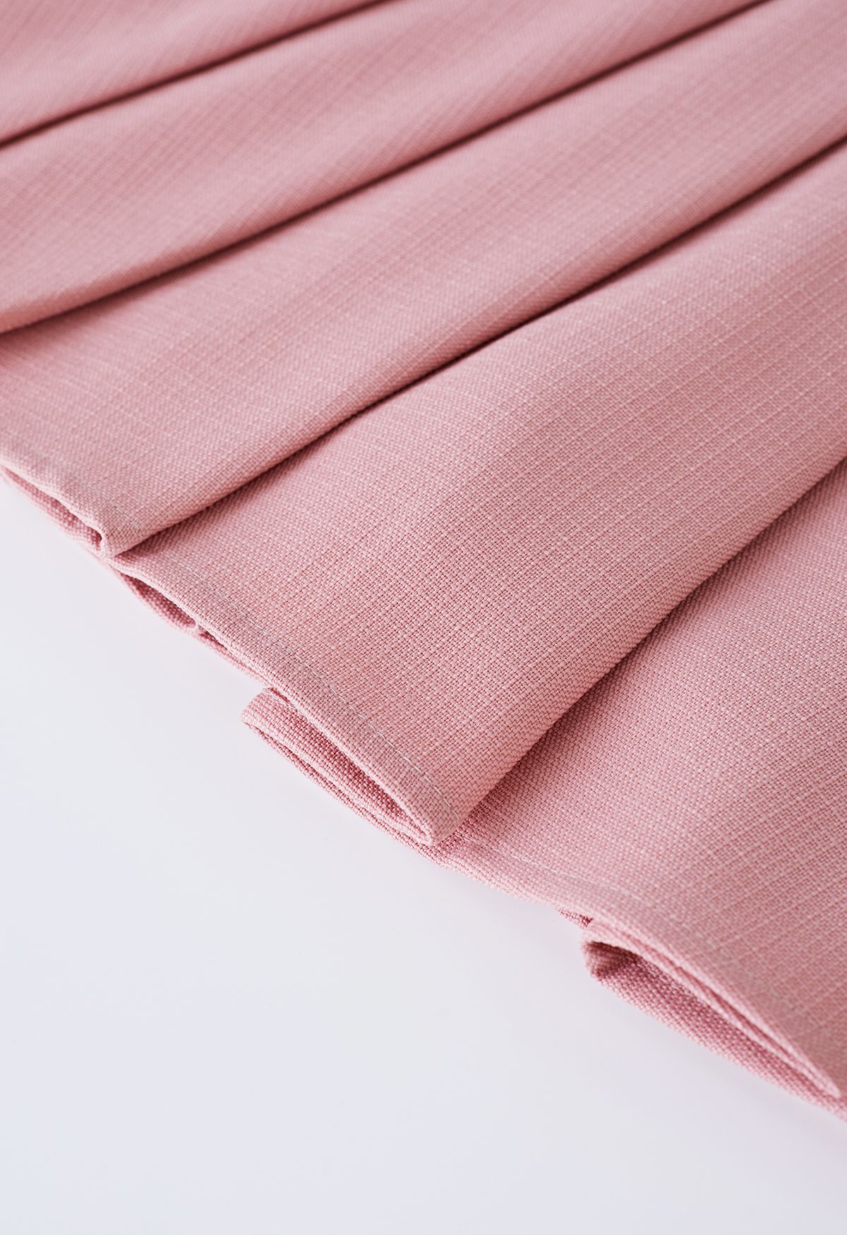 Mini-jupe évasée plissée à boutons dorés en rose