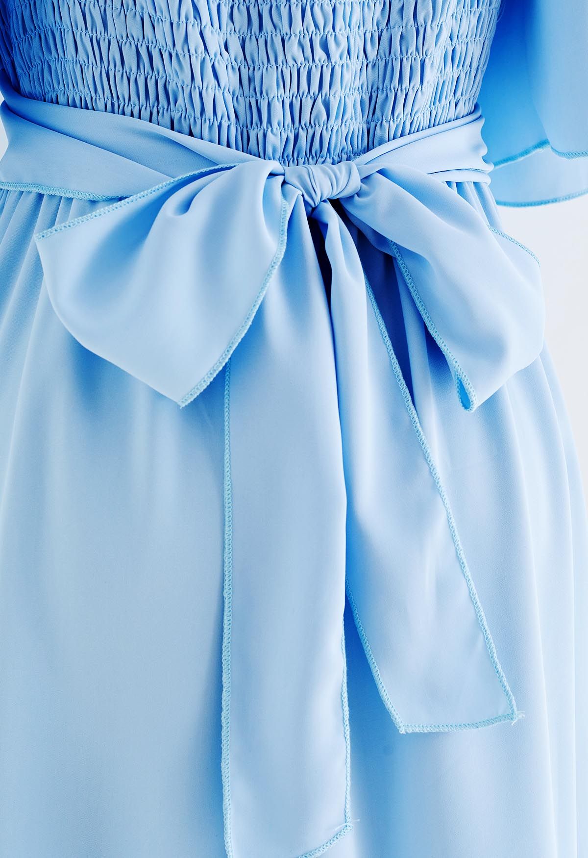 Robe volantée à manches flottantes avec ruban croisé en bleu