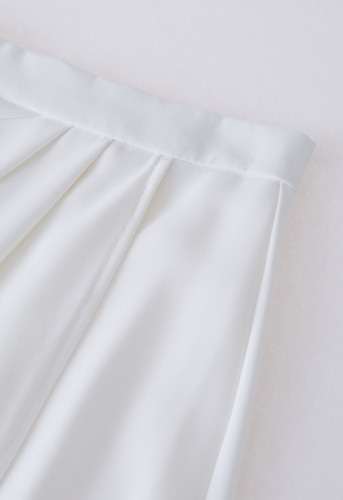 Jupe mi-longue à rabat plissé sur le côté en blanc