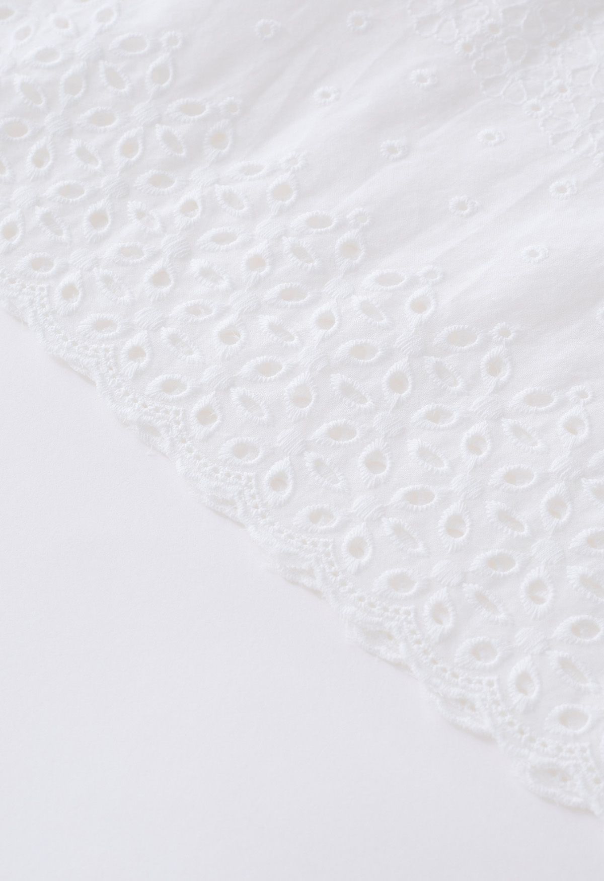 Jupe mi-longue en coton à œillets brodés fleuret en blanc
