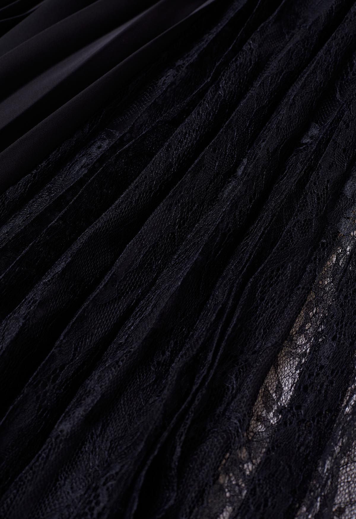 Jupe mi-longue plissée à empiècements en dentelle, noire