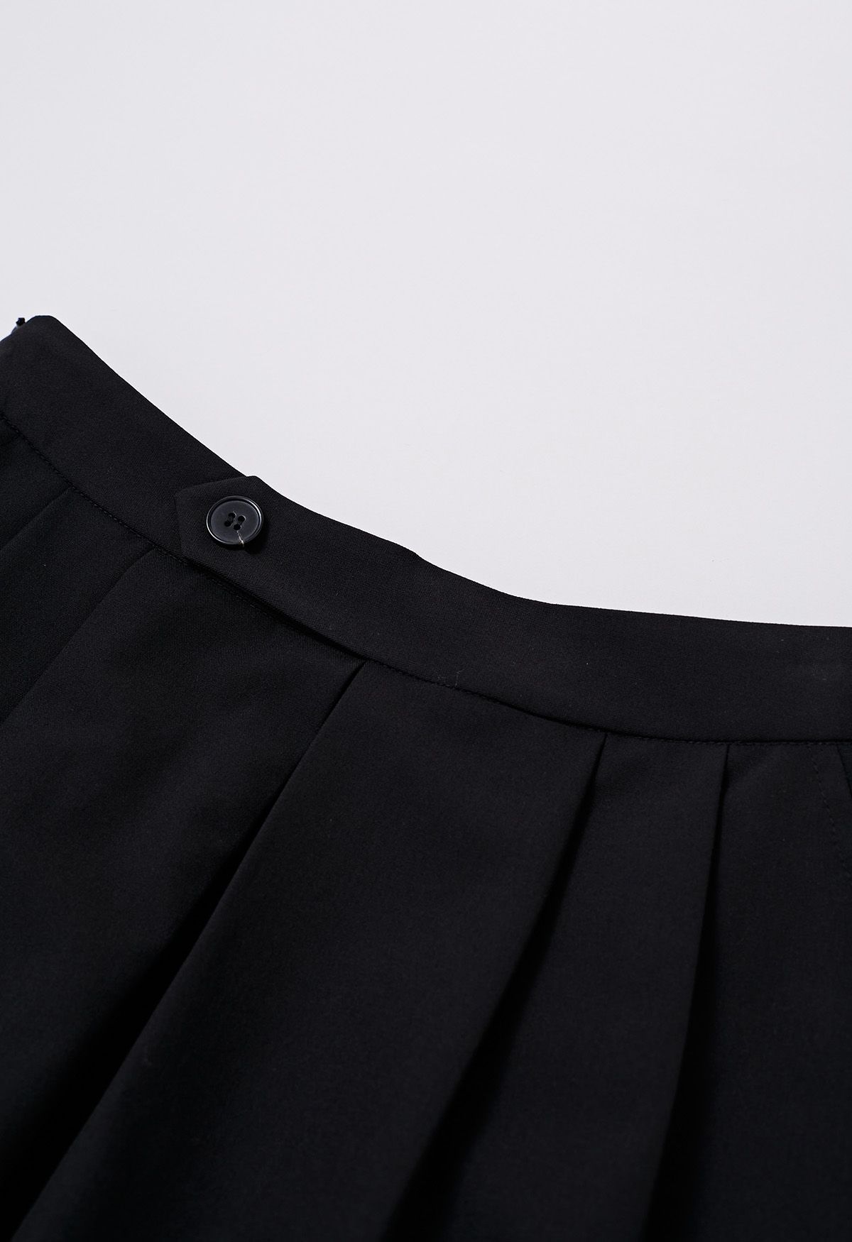 Jupe trapèze plissée décorée de boutons en noir