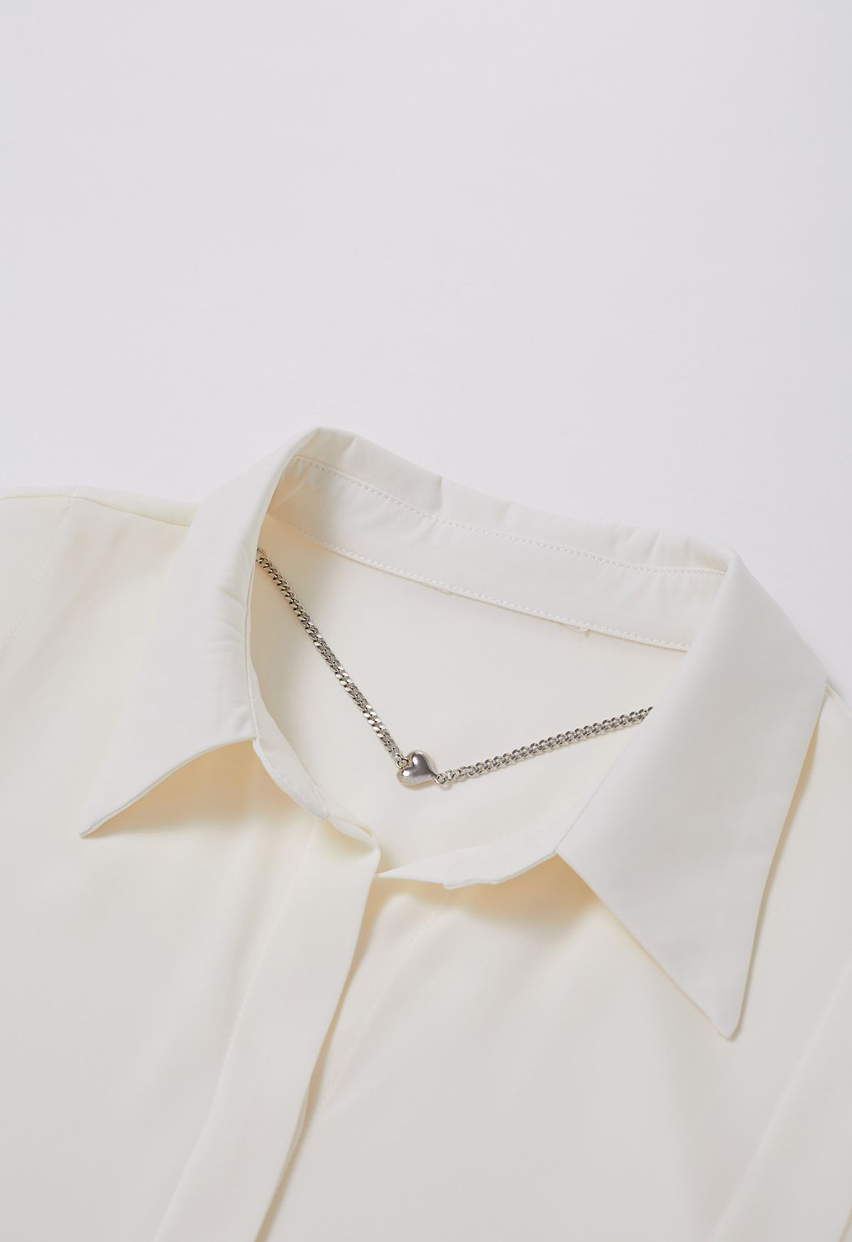 Chemise en satin à col en V avec collier cœur en crème