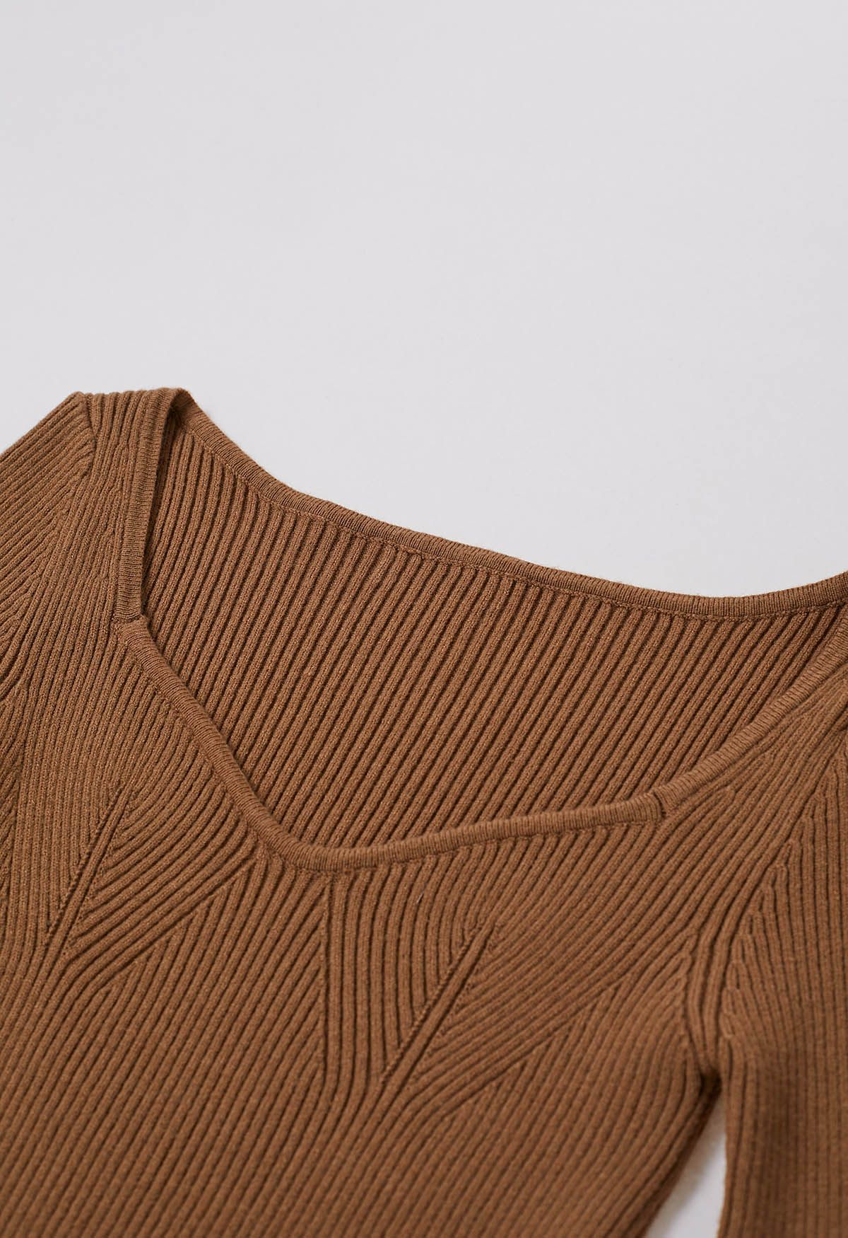 Haut en tricot à encolure ondulée et poignets bordés de plumes en beige