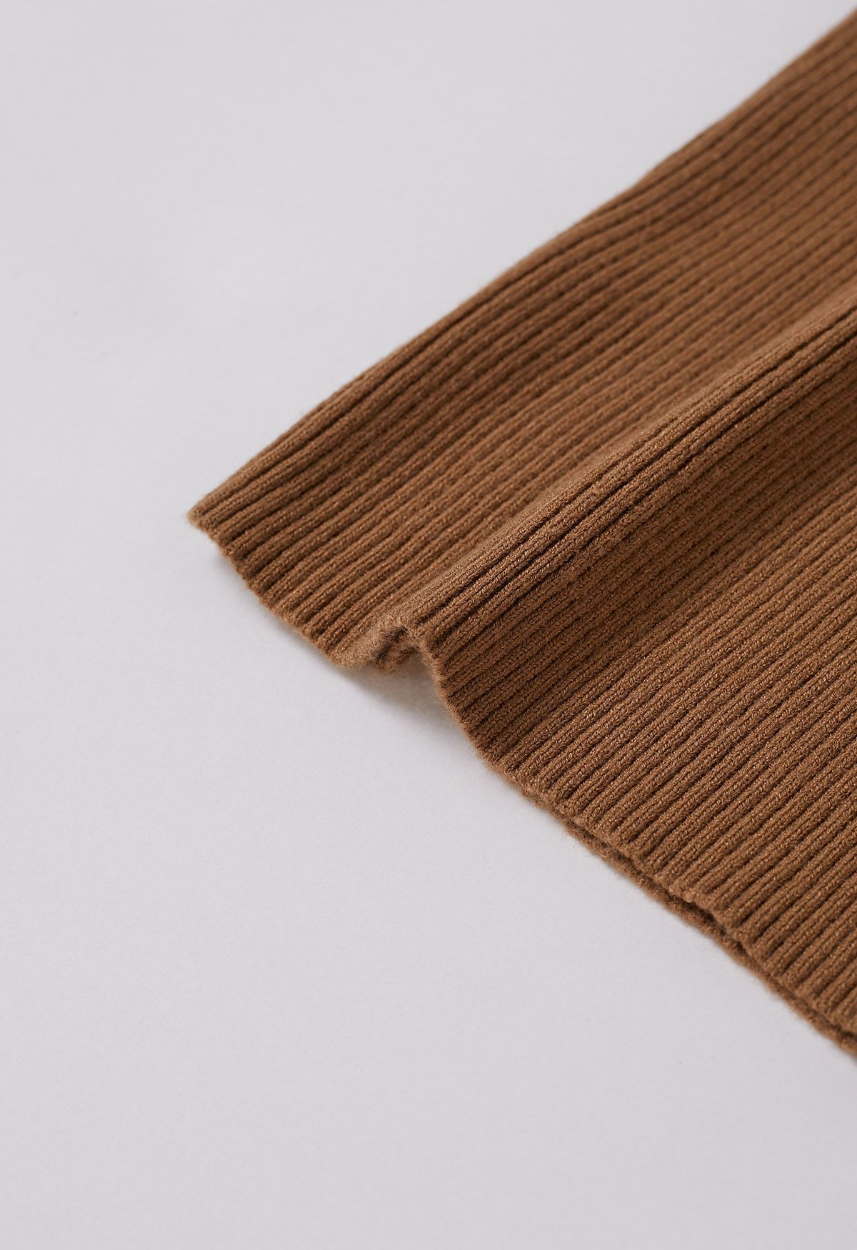 Haut en tricot à encolure ondulée et poignets bordés de plumes en beige