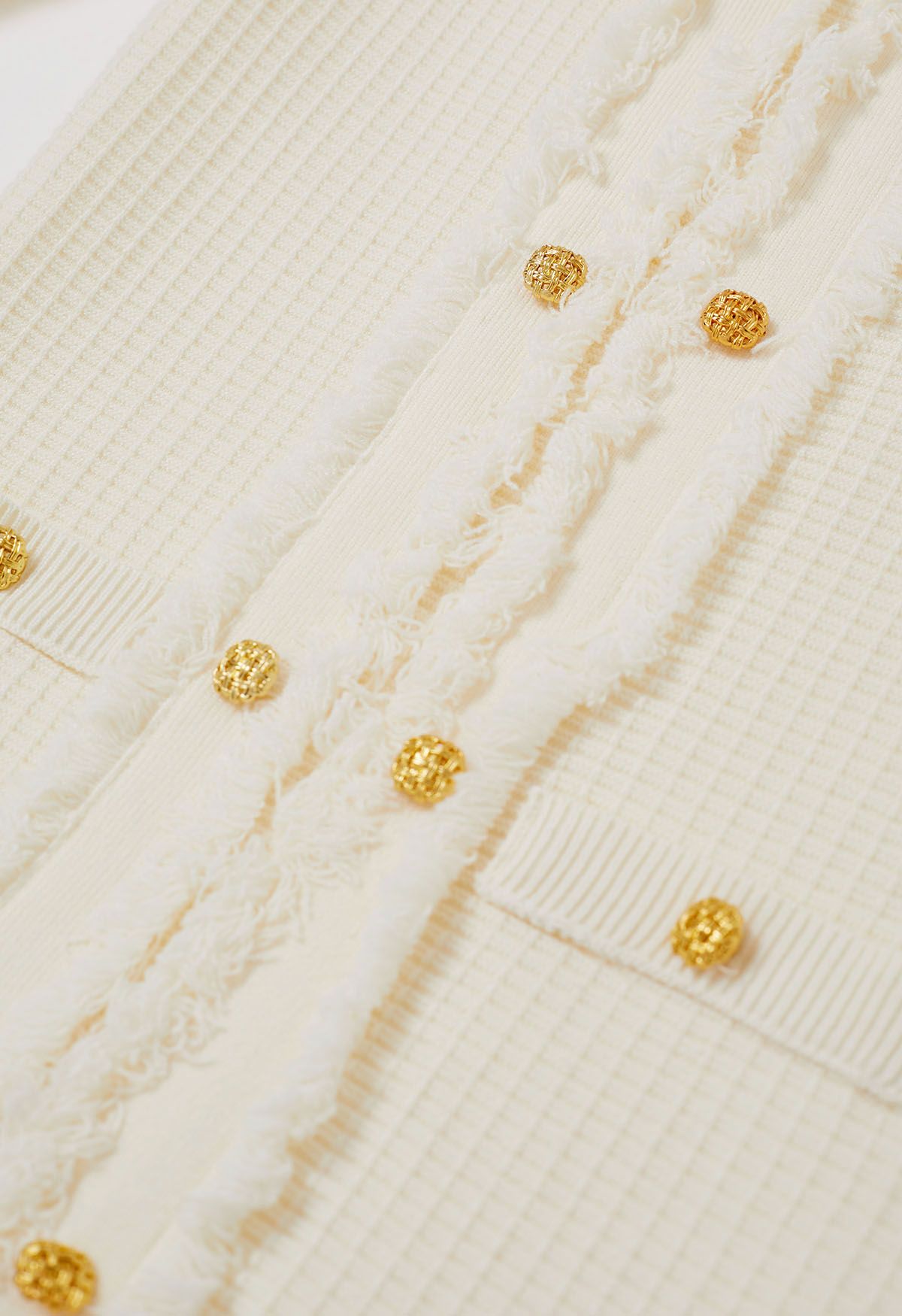 Robe en tricot gaufré à boutons dorés et à franges en crème