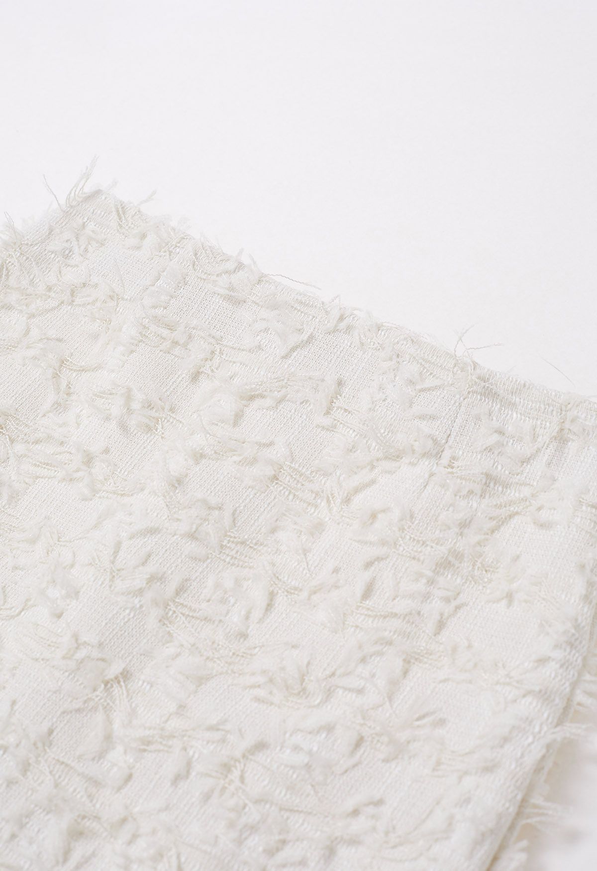 Adorable mini-jupe bourgeon en tweed à franges en crème