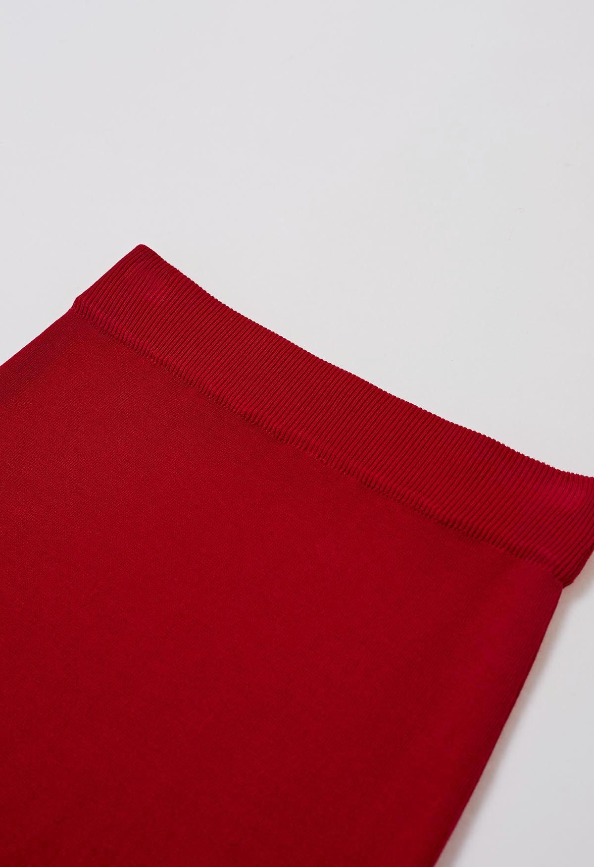 Jupe mi-longue en tricot fendue sur le côté et découpée en rouge
