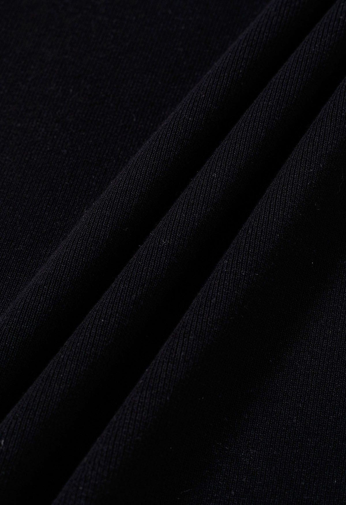 Jupe mi-longue en tricot fendue sur le côté et découpée en noir
