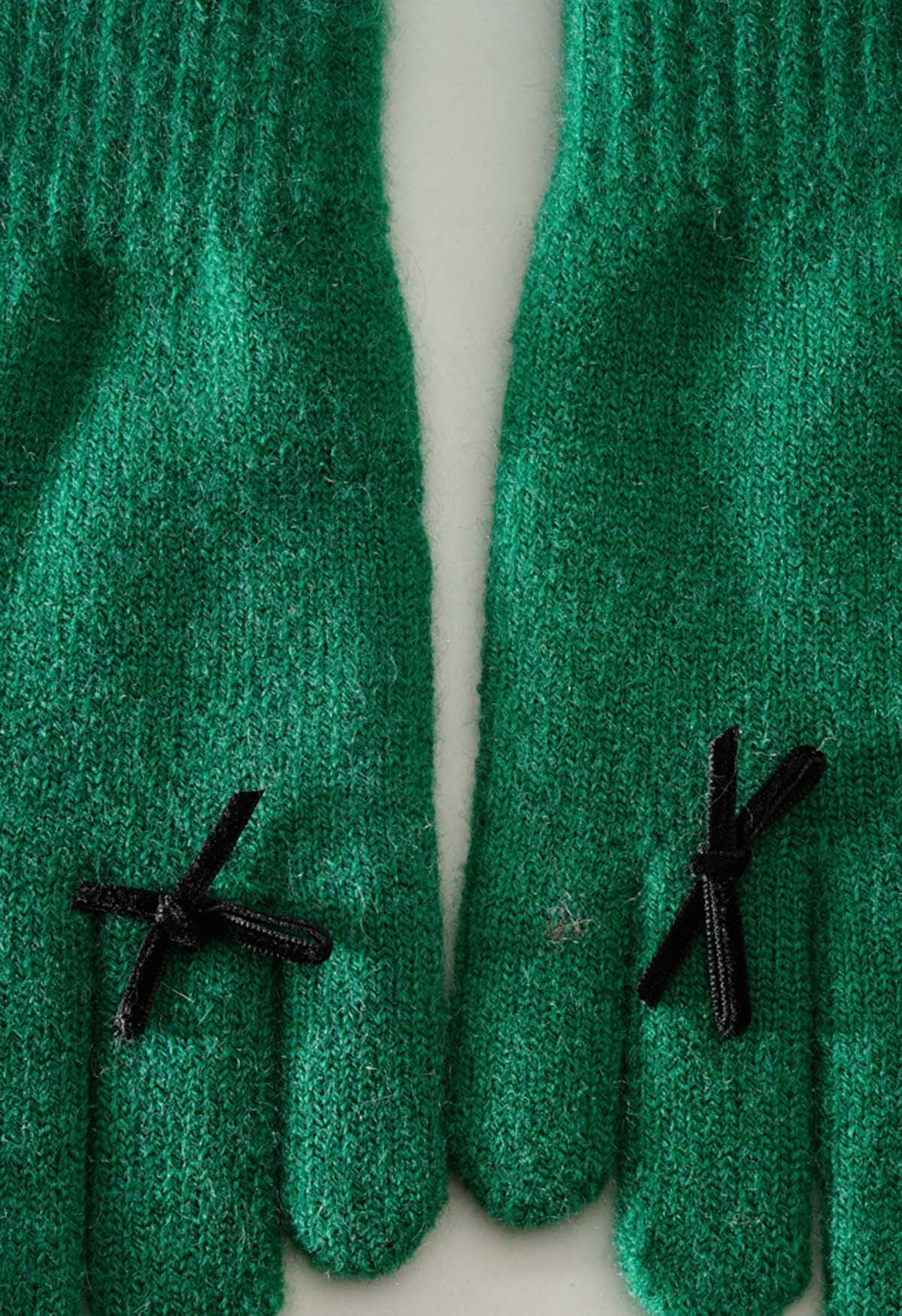 Gants en tricot avec trou pour les doigts et décoration avec nœud papillon en vert