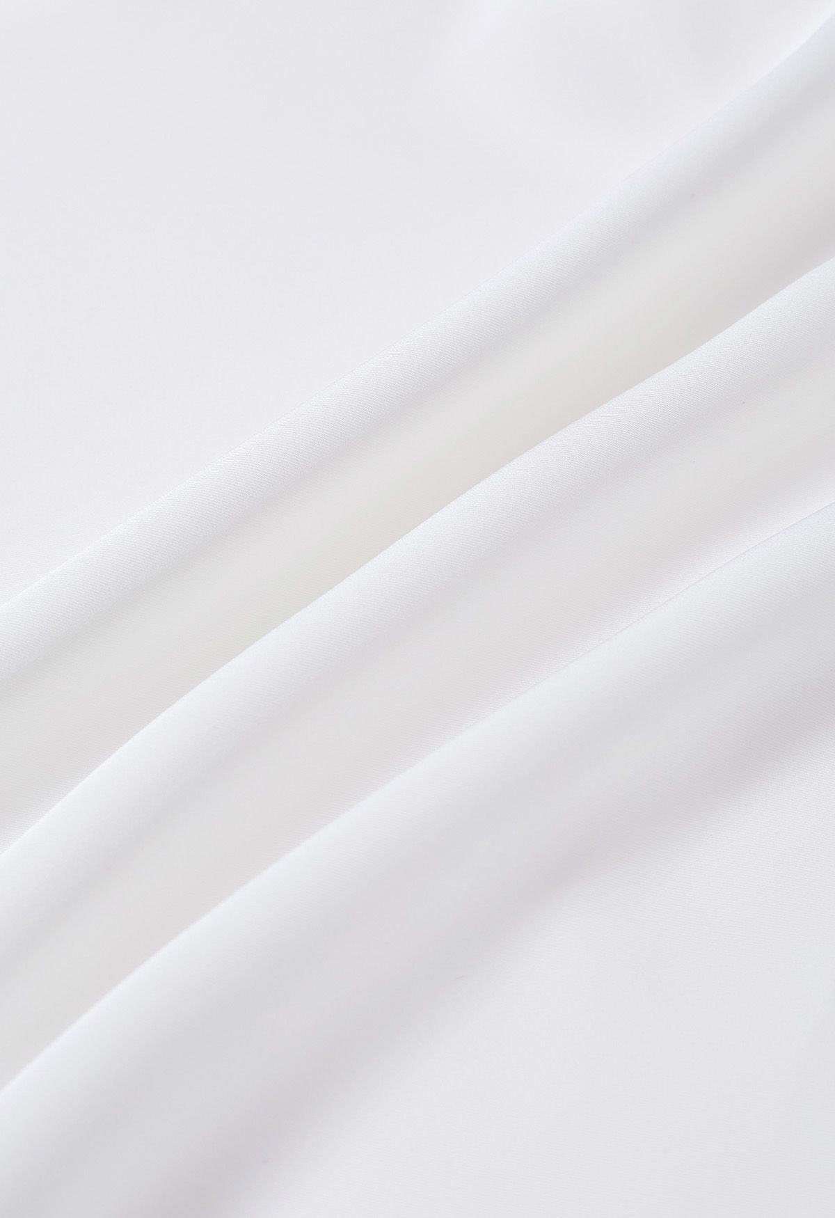 Haut asymétrique froncé en satin à manches longues en blanc