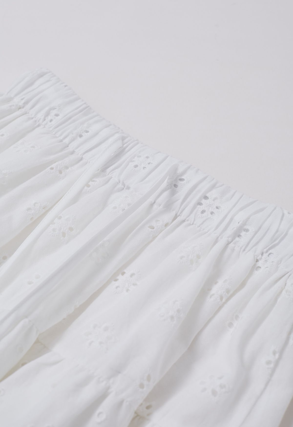 Mini-jupe à volants brodée d'œillets en blanc