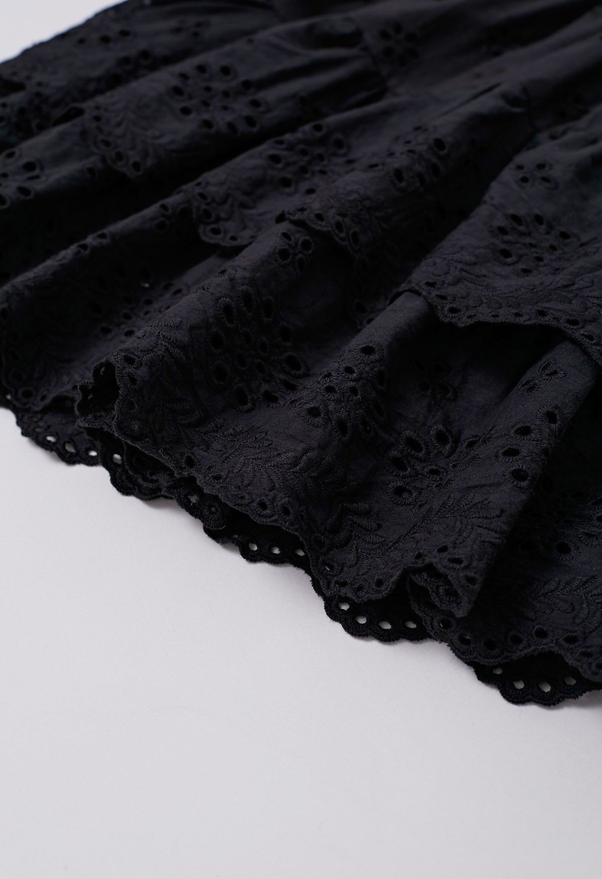 Mini-jupe à volants brodée d'œillets en noir